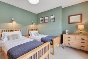 a bedroom with two beds and a wooden dresser at Glancoegen in Cemmaes