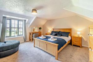 a bedroom with a large bed and a couch at Chestnut Cottage - Stackpole in Stackpole Elidor