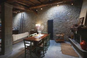 a dining room with a table and a stone wall at Historic Sillico Relais Hot Tub, Sauna e Charme in Sillico