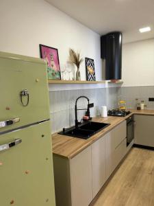 a kitchen with a sink and a refrigerator at Super cozy corner in Itʼkhvisi