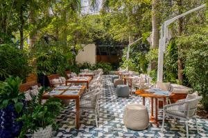a patio with tables and chairs and trees at Mr C Miami Coconut Grove in Miami