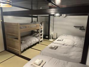 a bedroom with two bunk beds and a bunk bed at BISHU to YADO in Ichinomiya