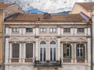une vieille maison avec des fenêtres et un balcon dans l'établissement Sokak Heritage Apartments, à Bitola
