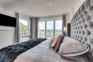 a large bed in a bedroom with a large window at Rock House in Ilfracombe