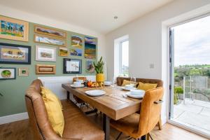 une salle à manger avec une table et des chaises en bois dans l'établissement Sandpiper Cottage, à Saundersfoot