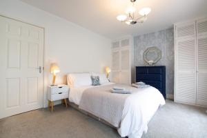 une chambre avec un lit, une commode et un miroir dans l'établissement Sandpiper Cottage, à Saundersfoot