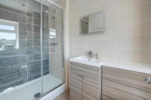 une salle de bain avec une douche, un lavabo et une baignoire dans l'établissement Sandpiper Cottage, à Saundersfoot 21 autres photos