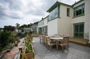 a patio with a table and chairs and a house at Orchard Cottage in Newlyn