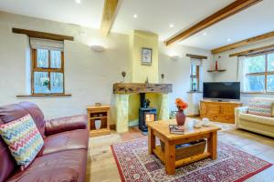 a living room with a couch and a fireplace at Chestnut Cottage in Manorbier