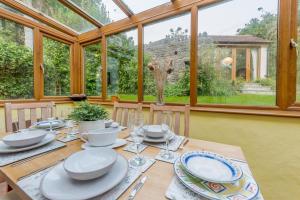 a dining room with a table with plates and glasses at Chestnut Cottage in Manorbier