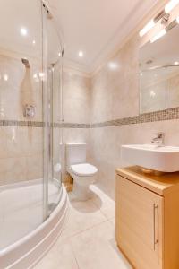 a bathroom with a toilet and a sink and a shower at York Mansions Apartment in Broadstairs +6 photos