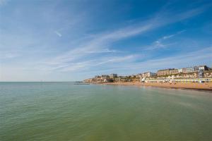 a view of a beach with buildings and the ocean at York Mansions Apartment in Broadstairs