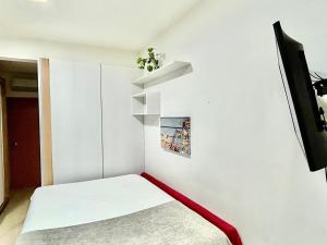 a small room with a bed and a tv at Estúdio Fit Caiobá: aconchegante e bem equipado. in Matinhos