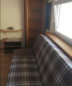 a living room with a couch and a window at 3 kambariu butas in Klaipėda