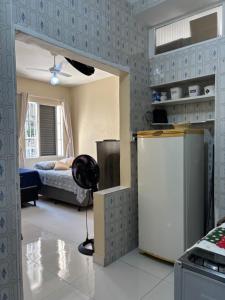 uma sala de estar com um frigorífico e um quarto em Kit Jd Guilhermina na Praia Grande