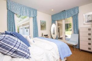 a bedroom with a bed with blue curtains and a window at Wine Country Retreat Zinfandel Lane Villa in St. Helena +29 photos