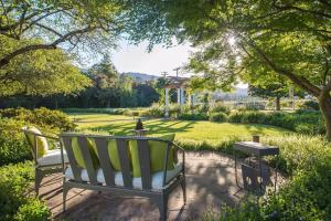 a bench in a garden with a view of a park at Wine Country Retreat Zinfandel Lane Villa in St. Helena