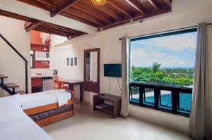 1 dormitorio con ventana grande con vistas en Agos Boracay Rooms + Beds, en Boracay