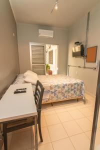 Un dormitorio con una cama y una mesa y una mesa y una silla. en K3 Residence Taquaral, en Campinas