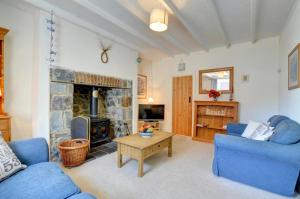 a living room with a blue couch and a fireplace at Elvor in New Quay