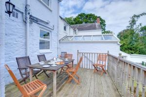 a patio with a table and chairs on a balcony at Elvor in New Quay