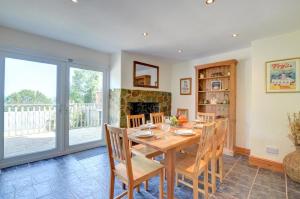 a dining room with a table and chairs and a fireplace at Elvor in New Quay