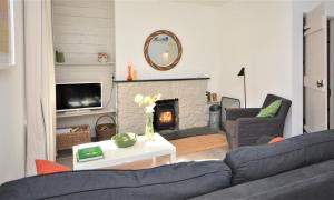 a living room with a couch and a fireplace at The White Cottage in Saint Winnow