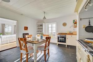 a kitchen with a table and chairs in a room at The White Cottage in Saint Winnow