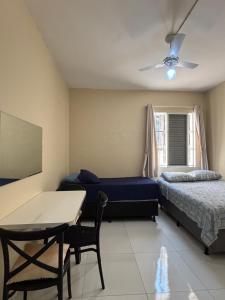 um quarto com uma cama e uma mesa e uma cama e um sofá em Kit Jd Guilhermina na Praia Grande