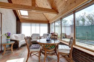 a screened in porch with a table and chairs at Tyn Coed in Moelfre