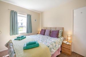 a bedroom with a bed with two pillows on it at Llwyn y Morfa in Morfa Nefyn