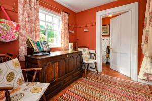 a home office with orange walls and a window at Trefaes in Abersoch +37 photos