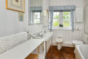 a bathroom with a tub and a sink and a toilet at Trefaes in Abersoch