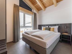 a bedroom with a large bed and a large window at Alpenchalet Lambert in Sankt Lambrecht
