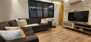 a living room with a couch and a flat screen tv at Resort&House,4 Quartos, 8 pessoas, Beach tenis, Bike, Golfe, Pesca, Ar, Wifi fibra, TV a cabo e Lareira in Santa Bárbara do Rio Pardo