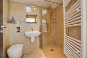 a bathroom with a toilet and a sink and a shower at Ocean Blue in Porthleven +7 photos