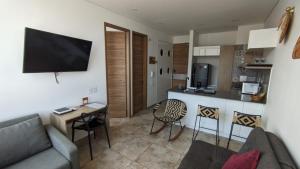 a living room with a couch and a table and a kitchen at Vita905 RODADERO in Santa Marta
