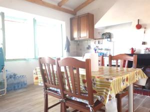 a kitchen with a table with chairs and a table and a kitchen at Casetta Patrizia in Capo Comino