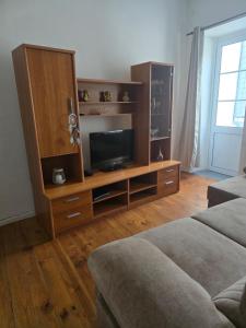 a living room with a entertainment center with a flat screen tv at Casa Apito Dourado in Ponta Delgada