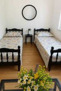 a bedroom with two beds and a table with flowers at Holiday house with a parking space Srijane, Zagora - 22621 in Smoljanovići