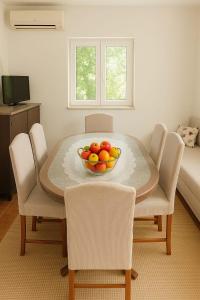 a dining room table with a bowl of fruit on it at Holiday house with a parking space Srijane, Zagora - 22621 in Smoljanovići