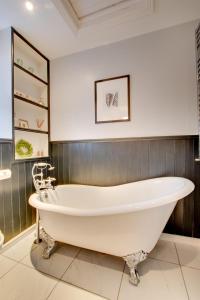 a large white bath tub in a bathroom at Hillside in Croyde