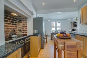 eine Küche mit einem Tisch mit einer Obstschale darauf in der Unterkunft North End House in Fowey