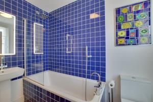 ein blau gefliestes Bad mit einer Badewanne und einem Waschbecken in der Unterkunft North End House in Fowey + 19 Fotos