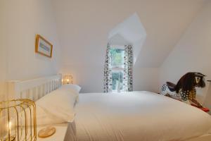 ein Schlafzimmer mit einem großen weißen Bett und einem Fenster in der Unterkunft North End House in Fowey