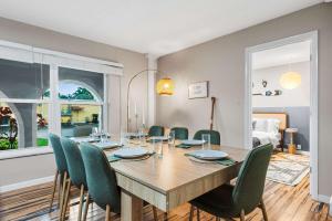 Un comedor con una mesa de madera y sillas verdes. en Canal views featuring indoor pool, en Fort Lauderdale