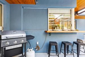 Una cocina azul con estufa y taburetes. en Canal views featuring indoor pool, en Fort Lauderdale