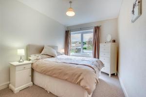 a white bedroom with a bed and a window at Castle View in Saundersfoot