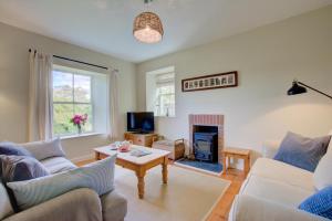 a living room with two couches and a fireplace at St Teresas Cottage in Saint Mawgan