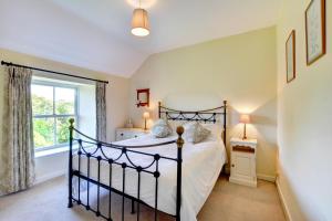 a bedroom with a bed and a window at St Teresas Cottage in Saint Mawgan